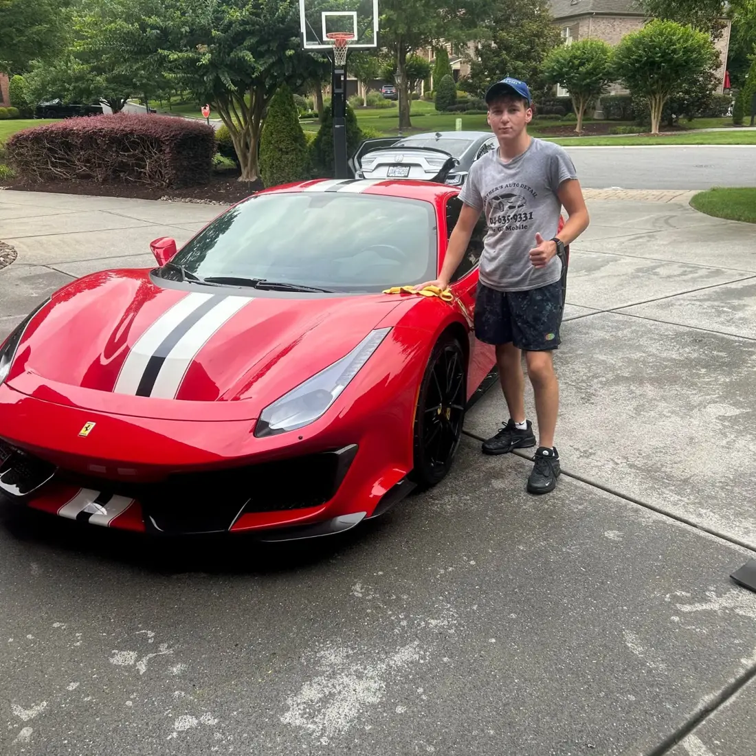 Brothers Detailing finishing a red Ferrari in a Waxhaw driveway